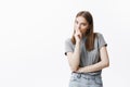 Close up portrait of beautiful dark-haired caucasian young woman with long hair in grey t shirt and jeans lookin in Royalty Free Stock Photo