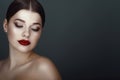 Close up portrait of beautiful dark-haired model with perfect make up and centre part sleek ponytail looking down