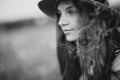 Close-up portrait of a beautiful free girl in a summer field of red poppies. Soft selective focus. Black and white art photo.