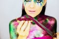 Close up portrait of a beautiful girl with creative glitter make up with knife and snack covered in glitter Royalty Free Stock Photo