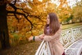 Close up portrait of a Beautiful girl in dark dress and black hat standing near colorful autumn leaves. Art work of romantic woman Royalty Free Stock Photo