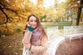 Close up portrait of a Beautiful girl in dark dress and black hat standing near colorful autumn leaves. Art work of romantic woman Royalty Free Stock Photo