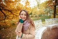 Close up portrait of a Beautiful girl in dark dress and black hat standing near colorful autumn leaves. Art work of romantic woman Royalty Free Stock Photo