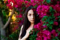 Close up portrait of a beautiful girl near colorful flowers. Pretty tender young woman model looking at camera. Royalty Free Stock Photo