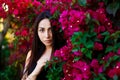 Close up portrait of a beautiful girl near colorful flowers. Pretty tender young woman model looking at camera. Royalty Free Stock Photo