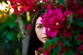 Close up portrait of a beautiful girl near colorful flowers. Pretty tender young woman model looking at camera. Royalty Free Stock Photo