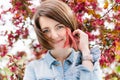 Close up portrait of a beautiful girl with pink hair standing in a blooming apple garden. Spring, outdoors. Royalty Free Stock Photo