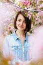 Close up portrait of a beautiful girl with pink hair standing in a blooming apple garden. Spring, outdoors. Royalty Free Stock Photo