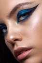 Close up portrait of a beautiful girl with professional makeup, ideal skin, bright blue graphic smokey eyes Royalty Free Stock Photo