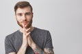 Close up portrait of beautiful happy caucasian man with beard,fashionable hairstyle and tattooed arm wearing grey shirt Royalty Free Stock Photo