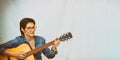 Close-up portrait of a Beautiful happy dark-haired young woman in glasses playing the guitar widely. Banner.Toning. Copy Royalty Free Stock Photo