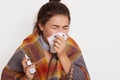 Close up portrait of beautiful lady suffers from illness, look dripping nasal spray isolated over white background, blows her nose Royalty Free Stock Photo