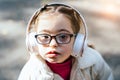 Close up portrait of beautiful little girl in eyeglasses with down syndrome smiling and looking into camera with Royalty Free Stock Photo