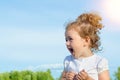 Close up portrait of beautiful little girl, happy child. Positive kid outdoors on the blue sky background, smiling. Royalty Free Stock Photo