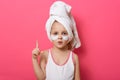 Close up portrait of beautiful little girl after shower posing isolated over pink background, female child with white towel on her Royalty Free Stock Photo