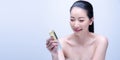 Close-up portrait of beautiful mature asian woman is holding beauty bottle of serum for applying makeup foundation . Skin care and