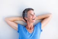 Close up beautiful mature woman smiling with hands behind head Royalty Free Stock Photo
