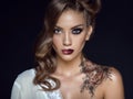 Close up portrait of beautiful model with artistic make up and hairstyle. Floral body art on her shoulder. Ideal woman concept