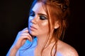 Close-up portrait of beautiful natural woman with freckles on her face and blue glittered smokey eyes make-up. Red Royalty Free Stock Photo