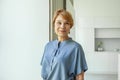 Close up portrait of beautiful older woman smiling and standing by wall