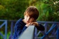 Close-up portrait of a beautiful red-haired boy with a very serious look. A sad expression on his face. Outdoor, copy space Royalty Free Stock Photo