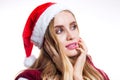 Close-up portrait of beautiful Santa woman in hat on white background. The girl dreams and thinks about a gift for the new year