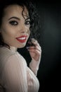 Close up portrait of a beautiful smiling young woman with curly black hair and red lipstick Royalty Free Stock Photo