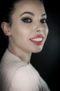 Close up portrait of a beautiful smiling young woman with curly black hair and red lipstick Royalty Free Stock Photo