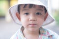 close up portrait of beautiful sweet boy, wearing White bucket hat and colorful shirt, looking at camera, big dark eyes Royalty Free Stock Photo