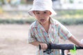 close up portrait of beautiful sweet boy, wearing White bucket hat and colorful shirt, looking at camera, big dark eyes Royalty Free Stock Photo
