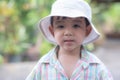 close up portrait of beautiful sweet boy, wearing White bucket hat and colorful shirt, looking at camera, big dark eyes Royalty Free Stock Photo