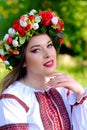 Close-up portrait of a beautiful Ukrainian girl in a traditional dress and a wreath on her head. Vertical image