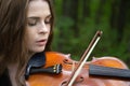 Portrait close up of a beautiful girl violinist who lowered his eyes enthusiastically playing the violin romantic work Royalty Free Stock Photo