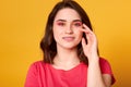 Close up portrait of beautiful woman with dark hair and male up, looking mysteriously at camera, wearing casual outfit, touching Royalty Free Stock Photo