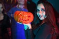 Close up portrait of beautiful woman dressed up like a witch for halloween holding a pumpkin