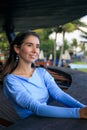 Close up portrait of beautiful woman with jewelry. Smiling Caucasian woman wearing blue dress and sitting in the beach bar. Travel Royalty Free Stock Photo