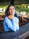 Close up portrait of beautiful woman with jewelry. Smiling Caucasian woman wearing blue dress and sitting in the beach bar. Travel Royalty Free Stock Photo