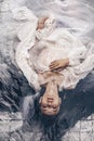 Close up portrait of beautiful woman lying in water with fabric. Royalty Free Stock Photo