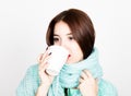 Close-up portrait of beautiful woman in a woolen scarf, drinking hot tea or coffee from white cup Royalty Free Stock Photo