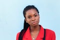 Close up portrait of a beautiful young african american woman with pigtails in red business suit smiling over blue background Royalty Free Stock Photo