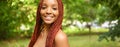 Close up portrait Beautiful young African American woman with red braids hair, perfect white teeth smiling outside Royalty Free Stock Photo