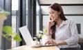 Close up portrait of a beautiful young Asia woman smiling and looking at laptop screen Royalty Free Stock Photo