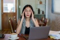 Close-up portrait of beautiful young Asian business woman face is massaging the head with both hands headache from work stress