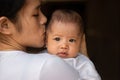 Close-up portrait of beautiful young Asian mother holding baby girl smiling and kissing her`s daughter Royalty Free Stock Photo