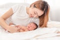 Close up portrait of beautiful young asian mother with newborn baby. Side view of a young woman playing with her little baby in Royalty Free Stock Photo