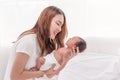 Close up portrait of beautiful young asian mother with newborn baby. Side view of a young woman playing with her little baby in Royalty Free Stock Photo