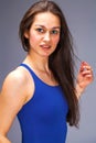 Close up portrait of a beautiful young brunette girl in a blue solid swimsuit