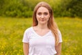Close up portrait of beautiful young caucasian woman resting in nature, poses isolated over meadow background, cute female looking Royalty Free Stock Photo