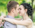 Close-up portrait of beautiful young couple female bride and male bridegroom kissing in summer park. Woman wife hugging man husban Royalty Free Stock Photo