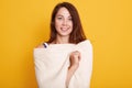 Close up portrait of beautiful young darkhaired woman wrapped in spa towel, charming female posing isolated over pink studio